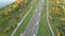 Aerial top view of highway road. Drone view of the elevated road, traffic junctions, and green garden. Transport trucks and cars