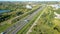 Aerial top view of highway road. Drone view of the elevated road, traffic junctions, and green garden. Transport trucks and cars