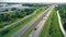 Aerial top view of highway road. Drone view of the elevated road, traffic junctions, and green garden. Transport trucks and cars