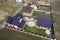 Aerial top view of house shingle roof on background of green lawn and colorful paved yard with geometrical abstract pattern