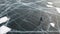 Aerial top view of a man ice skating outdoors on frozen water reservoir. Clip. Male tourist ice skating on frozen lake