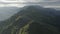 Aerial top view mountain ridge panorama flight through the clouds at sunrise