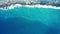 Aerial top view of ocean blue waves break on a beach