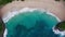 Aerial top view of ocean waves rolling on white sand beach in tropical paradise. Wild seaside with people. Turquoise