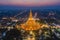 Aerial top view of Phra Pathommachedi temple at night. The golden buddhist pagoda with residential houses, urban city of Nakorn