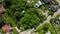 Aerial top view on private country side village houses on land plots among green trees. Traditional Russian countryside