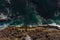 Aerial top view of raging ocean waves and fantastic rocky coast. Wallpaper design. Amazing landscape. View from above