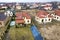 Aerial top view of residential area with new houses with roof solar photo voltaic panels, wind turbine mill and stand-alone