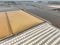 Aerial top view sea salt farm. Pile of brine salt. Raw material of salt industrial. Sodium Chloride mineral. Evaporation and