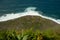 Aerial top view of sea waves against green Achadas da Cruz in Madeira Island, Portugal