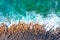 Aerial top view of sea waves hitting rocks on the beach