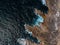 Aerial top view of sea waves hitting rocks on the beach with turquoise sea water. Amazing rock cliff seascape in the Portuguese co