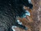 Aerial top view of sea waves hitting rocks on the beach with turquoise sea water. Amazing rock cliff seascape in the Portuguese co