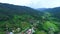 Aerial top view of sky road over top of mountain with farmland green jungle forest in sunny summer day at Pua district Nan provinc