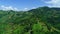 Aerial top view of sky road over top of mountain with farmland green jungle forest in sunny summer day at Pua district Nan provinc