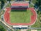 Aerial top view on a soccer field, grandstand, football field with red running track. race track in a stadium.