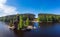 Aerial top view to wooden Church of St. Apostle Andrew First-Called on Vuoksa River with bridge. Temple on small island