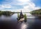 Aerial top view to wooden Church of St. Apostle Andrew First-Called on Vuoksa River with bridge. Temple on small island