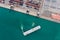Aerial top view tugboat dragging Large RoRo Roll on/off into Commercial dock import and export international on the green sea