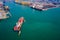 Aerial top view Tugboat pushing container ship  in sea port Thailand