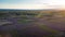 Aerial top view of vast colorful agricultural fields with country road on the middle