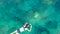 Aerial top view of woman snorkeling from above, girl snorkeler swimming in a clear tropical sea water with corals