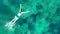 Aerial top view of woman snorkeling from above, girl snorkeler swimming in a clear tropical sea water with corals