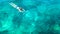 Aerial top view of woman snorkeling from above, girl snorkeler swimming in a clear tropical sea water with corals