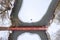 Aerial top view of the wooden footbridge over the icy frozen river