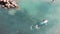 Aerial top view of young sportive boy on sup. Drone shot of attractive man in shorts surfing on sea. Blue clear water. Man floatin