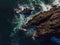 Aerial top views of amazing waves hugs stone grey rocks in the ocean. Wallpaper design. Fantastic landscape. Beauty of nature