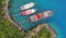 Aerial. Tourist boats standing in picturesque sea bay. People jump from ships and swim in the sea.