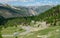 AERIAL: Tourists on road trip drive along the winding road in the European Alps.