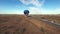 Aerial towards hot air balloon by highway in desert