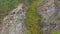 Aerial tracking of a girl climbing up on a rock. Slow motion