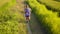 Aerial tracking on young sport runner man in off road running workout at a beautiful grass field landscape