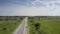 Aerial tractor drives along road mowing grass on roadside