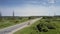 Aerial tractor lowers blade and mows grass along roadside