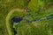 An aerial of a tractor mowing a lush grassland in summer