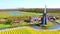 Aerial from a traditional windmill and blossoming tulip fields in the Netherlands