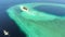 Aerial: tropical atoll view from above, blue lagoon turquoise water coral reef, Wakatobi Marine National Park, Indonesia - concept