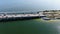 Aerial trucking shot over blue bay water and palm trees over bridge with traffic