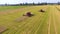 Aerial of two red combine harvesters working on large wheat field