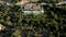 Aerial Upward Shot Of Luxurious Villas Amidst Green Trees On Mountains.