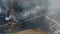 Aerial vertical footage of the woods covered in thick smoke, with a road and a river near by