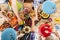 Aerial vertical view of table full of coloured traditional food and drinks and group of mixed ages generations people have fun