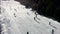 Aerial video clip of people skiing on a sunny winter mountain