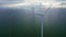 Aerial video. Enormous windmills stand in the sea along dutch Ijsselmeer by stormy and rainy day.
