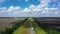 Aerial video, flying over a flat and straight highway going beyond the horizon