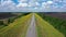 Aerial video, flying over a flat and straight highway going beyond the horizon